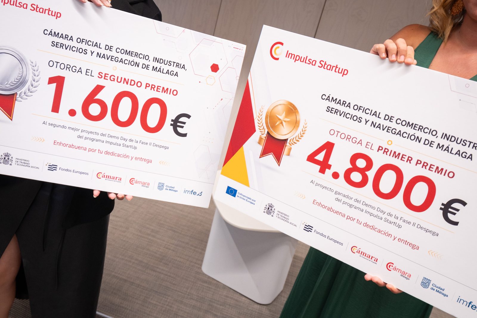 Cheques del primer premio (4.800 €) y del segundo premio (1.600 €) del Demo Day de Impulsa Startup.